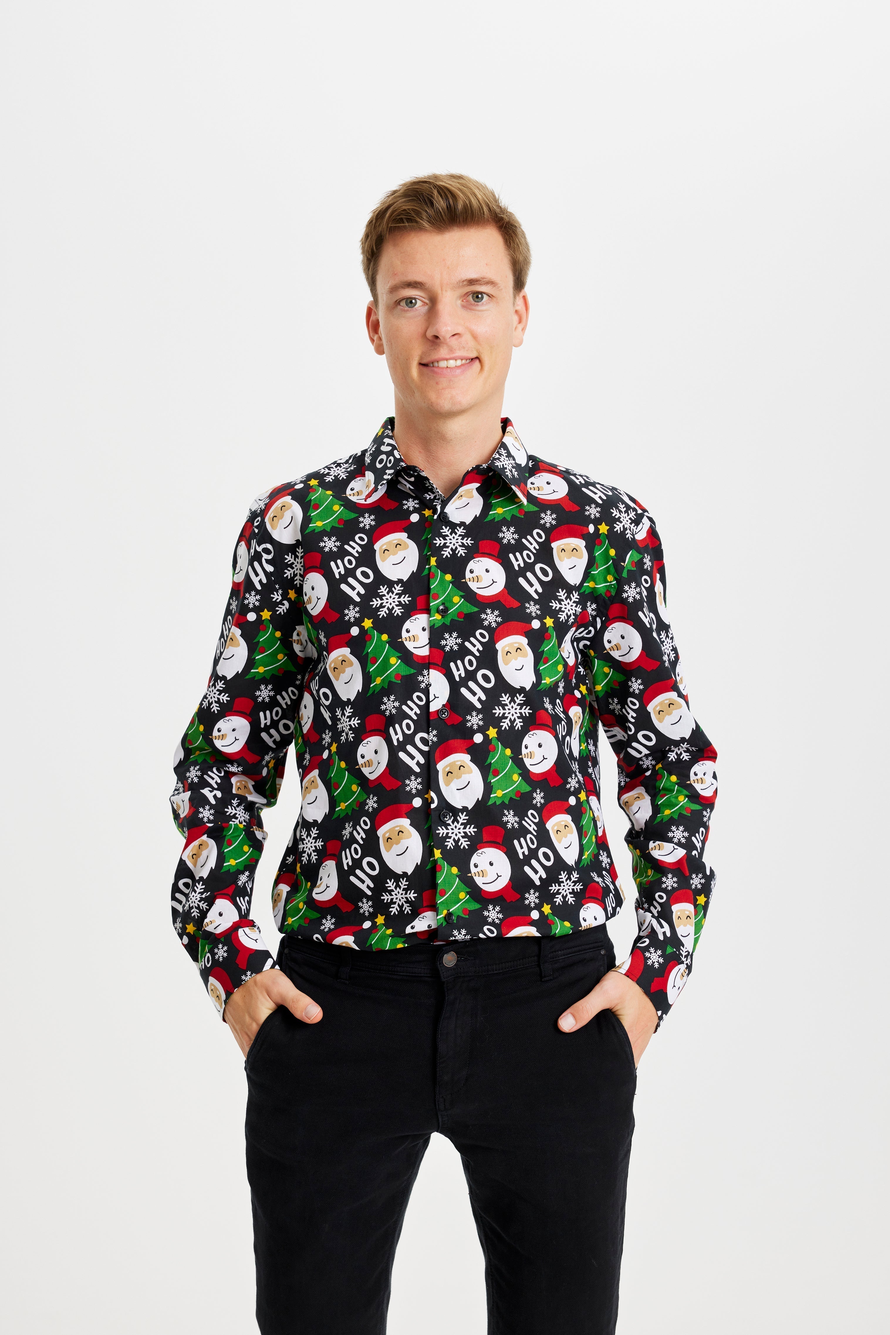 Un uomo sorridente che indossa una camicia natalizia a fantasia.